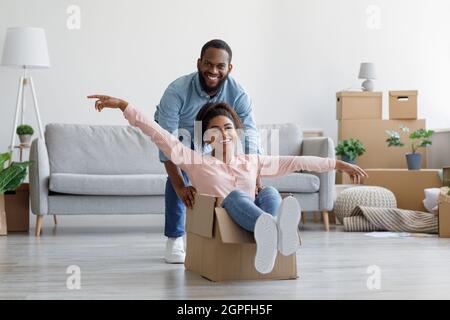 Happy black millennial couple in own home, buyers have fun, laughing on moving day Stock Photo