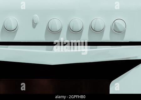 White kitchen gas stove with knobs for adjusting close-up. Stock Photo