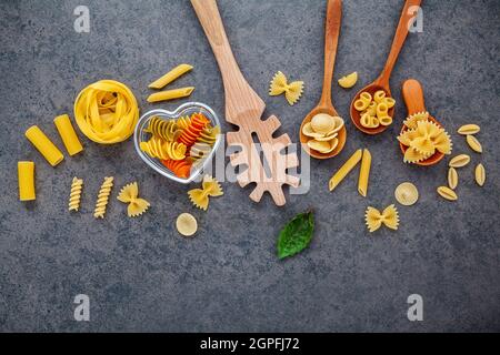 Italian foods concept and menu design. Various kind of Pasta Farfalle, Pasta A Riso, Orecchiette Pugliesi, Gnocco Sardo and Farfalle in wooden spoons Stock Photo