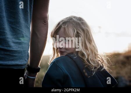 portrait of girl with a cheeky smile holding dads hand Stock Photo