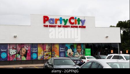 North Babylon, New York, USA - 18 August 2021: The entrance of a Party City Discount party super store from the parking lot with cars. Stock Photo