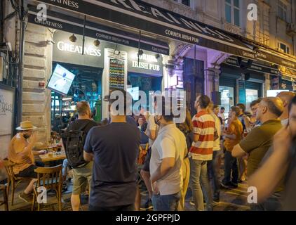 Beyoglu, Istanbul, Turkey - 07.07.2021: some Turkish people and tourists watching world cup football matches together in a bar outside at night in sum Stock Photo