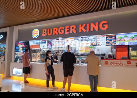 Sisli, Istanbul, Turkey - 07.13.2021: some Burger King costumers standing and people waiting in line for fast food orders in front of franchise restau Stock Photo