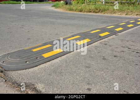 Traffic safety speed bump on an asphalt road. Speed bumps or speed breakers are traffic calming devices. Stock Photo