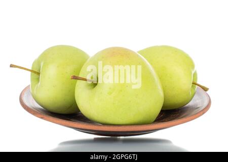 Three ripe green apples on a plate of clay, close-up, isolated on white. Stock Photo