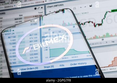 A smartphone with the BitMEX logo on the background of the live trading webpage. Stock Photo