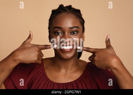 Positive black woman showing her beautiful white teeth Stock Photo