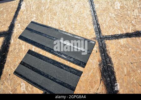 Asphalt Shingles Installation. Roofing preparation Asphalt Shingles  installing on house construction wooden roof with bitumen spray. Installing  asph Stock Photo - Alamy