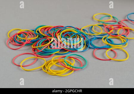Multicolored rubber bands on a gray background. Stationery. Clos Stock Photo