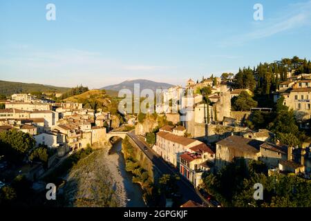 France, Vaucluse, Vaison la Romaine, Roman bridge over Ouveze River dating 1st century AD between the lower town and the medieval city with the belfry tower dated 14th century, former city hall and Mount Ventoux in the background (aerial view) Stock Photo