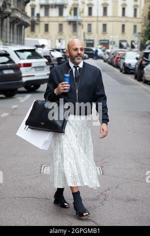 MILAN, ITALY - SEPTEMBER 25, 2021: Man with black bomber jacket and white skirt before Salvatore Ferragamo fashion show, Milan Fashion Week street sty Stock Photo