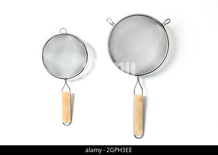 Two Fine Mesh Strainers - large and small. Silver colored metalic colanders with wooden handle isolated on a white background Stock Photo
