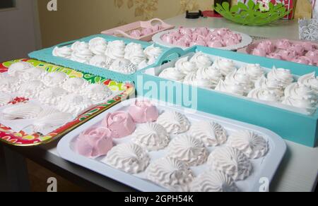 Homemade marshmallows of various shapes and colors are laid out on trays. Stabilization of Zephyr before packaging. Stock Photo