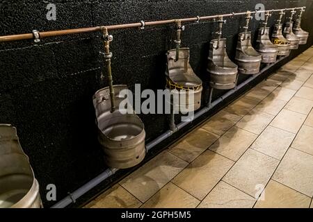 Urinals made from cut open beer barrels in Storms Packhus, Odense, Denmark Stock Photo