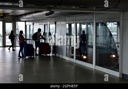 Inside Birmingham International Train Station passengers in silhouette with bags going to 'Air-Rail Link' system Stock Photo