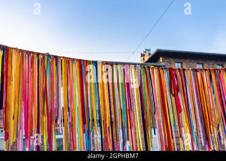 Garland made of colorful ribbons hanging outside the building in historical district Nikiszowiec in Katowice, Silesia, Poland. Blue sky in the backgro Stock Photo