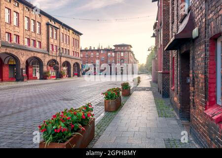 Traditional, silesian district Nikiszowiec. Renovated, old, brick block houses, build for coal miners in 1908-1919, cobblestone street. Beautiful, mor Stock Photo