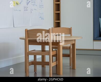 Interior of a spacious kindergarten room with small children tables and chairs.Children's table with chairs in the kindergarten .  Education learning Stock Photo