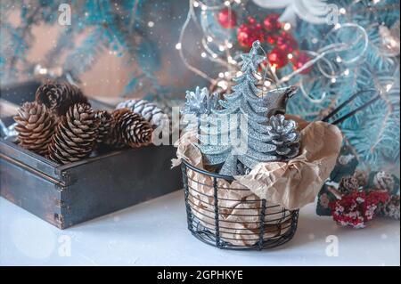 Christmas tree toys are lying in a metal basket on the Christmas table. The Concept Of A Winter Holiday. Beautiful Christmas toys are ready to Stock Photo