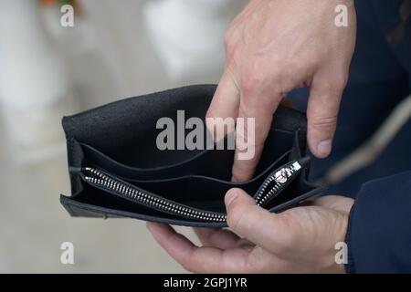 Man holding an empty black leather wallet Stock Photo