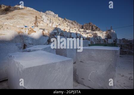 Carrara marble quarries, squarred white marble blocks on quarry of Gioia, bulldozers, machinery, excavators, Massa-Carrara, Lunigiana, Tuscany, Italy Stock Photo
