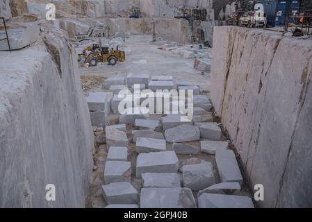 Carrara marble quarries, squarred white marble blocks on quarry of Gioia, bulldozers, machinery, excavators, Massa-Carrara, Lunigiana, Tuscany, Italy Stock Photo