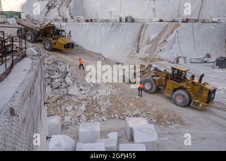 Carrara marble quarries, squarred white marble blocks on quarry of Gioia, bulldozers, machinery, excavators, Massa-Carrara, Lunigiana, Tuscany, Italy Stock Photo