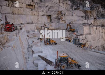 Carrara marble quarries, squarred white marble blocks on quarry of Gioia, bulldozers, machinery, excavators, Massa-Carrara, Lunigiana, Tuscany, Italy Stock Photo