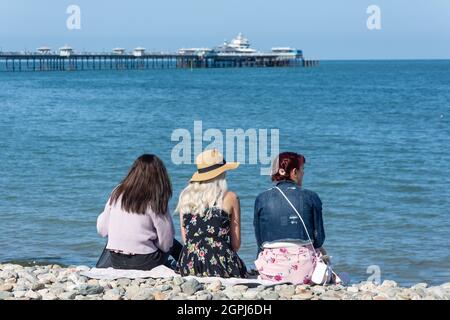 Young women sitting on beach, Llandudno, Conwy County Borough, Wales, United Kingdom Stock Photo