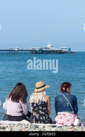 Young women sitting on beach, Llandudno, Conwy County Borough, Wales, United Kingdom Stock Photo