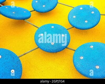 Blue circles with screw heads on a bright yellow background. Multi-colored rubberized coating. Abstract background. Stock Photo