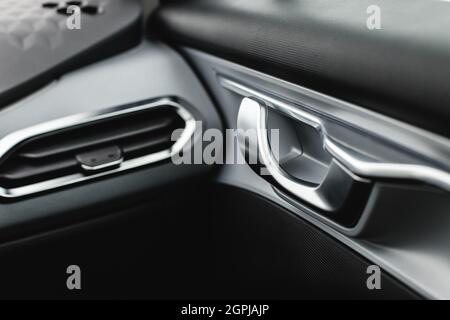 Inner door handle with lock unlock buttons, modern black car interior detail Stock Photo