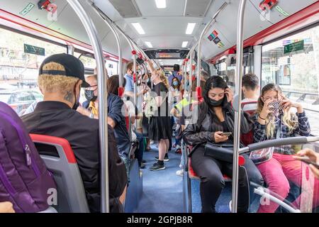 Barcelona, Spain - September 24, 2021: Crowds of people inside a bus. Interior view of a municipal bus with passengers wearing protective mask and dif Stock Photo