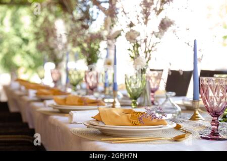 decorative table setting with beautiful dishes and flowers. Stock Photo