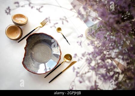 decorative table setting with beautiful dishes and flowers. Stock Photo