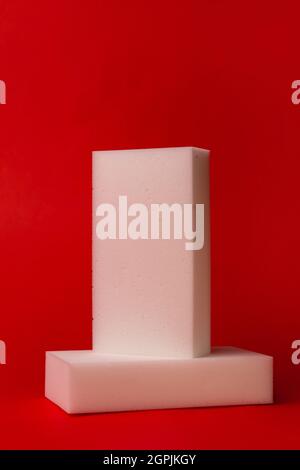 two white melamine sponges on a red background. Stock Photo