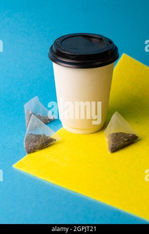 white paper cup and tea bags on the background. Stock Photo