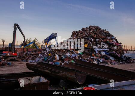 Metal recycling industry. Gripper excavator working on a scrap yard Stock Photo