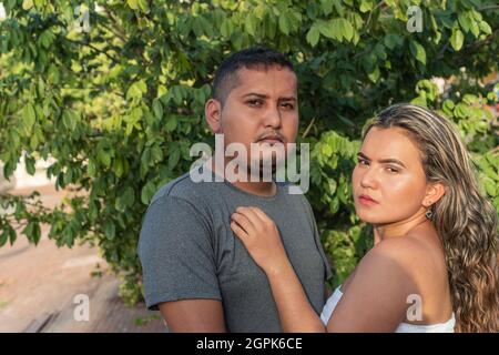 Young Hispanic Couple Looking in Camera Stock Photo