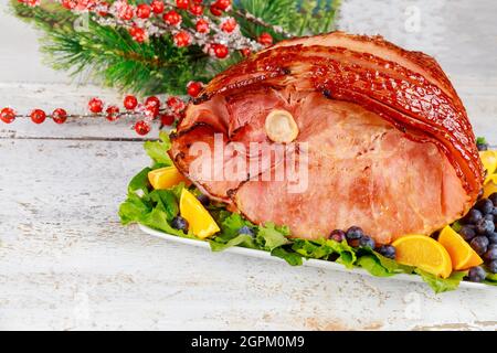 Whole pork ham with fresh fruits. Holiday Christmas meal. Stock Photo