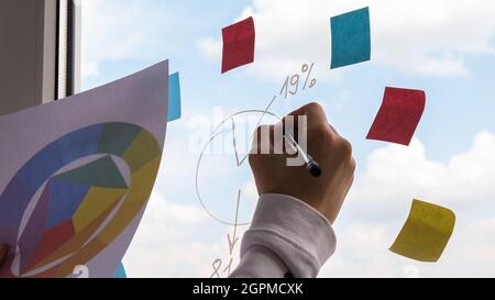 Female interior designer holding color palette in office. Workplace Workspace window. Architect at work. Engineering tools Colorful pie chart and grap Stock Photo