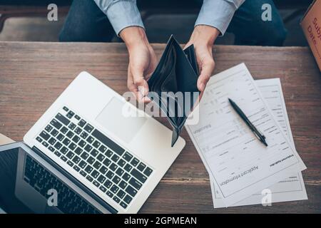 Office worker lost his job and open a wallet without money. Man empty wallet, man broke concept. Stock Photo