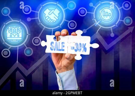 Writing displaying text Sale 30 Percent. Conceptual photo A promo price of an item at 30 percent markdown Hand Holding Jigsaw Puzzle Piece Unlocking Stock Photo
