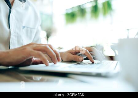 Young businessman working laptop in coffee shop. Business and freelance job concept. Stock Photo