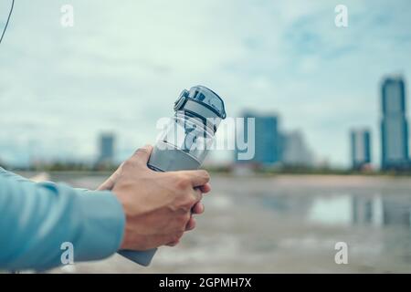 Fitness Man With Water Bottle Resting After Workout At Beach Stock Photo by  ©puhhha 109496632