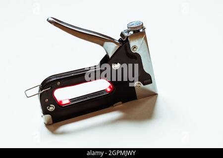 Furniture black construction stapler on a white background.  Stock Photo