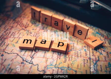 Wood square with word "map" and "travel" on the map. Travel plan concept. Stock Photo