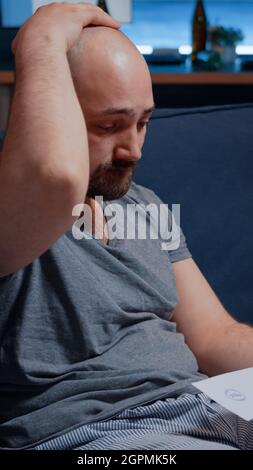 Worried anxious young man reading bad message in postal letter, get eviction, dismissal notice, feeling desperate, depressed, helpless frustrated. Stress victim has troubles with unpaid banking bills Stock Photo