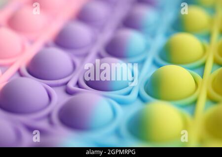 Multi-colored bubble wrap pops it in bright colors on table Stock Photo