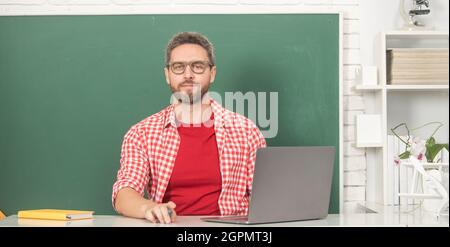 nerd student study online. private teacher in classroom with blackboard at pc. Stock Photo